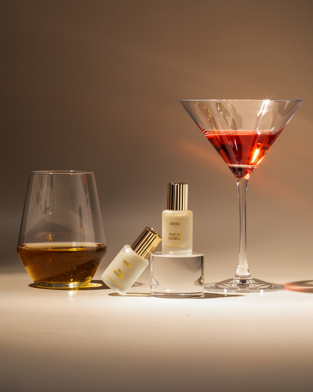 Sense Geneva Rue de Geneve and Old Money perfume oil bottles in frosted glass with red bottoms.