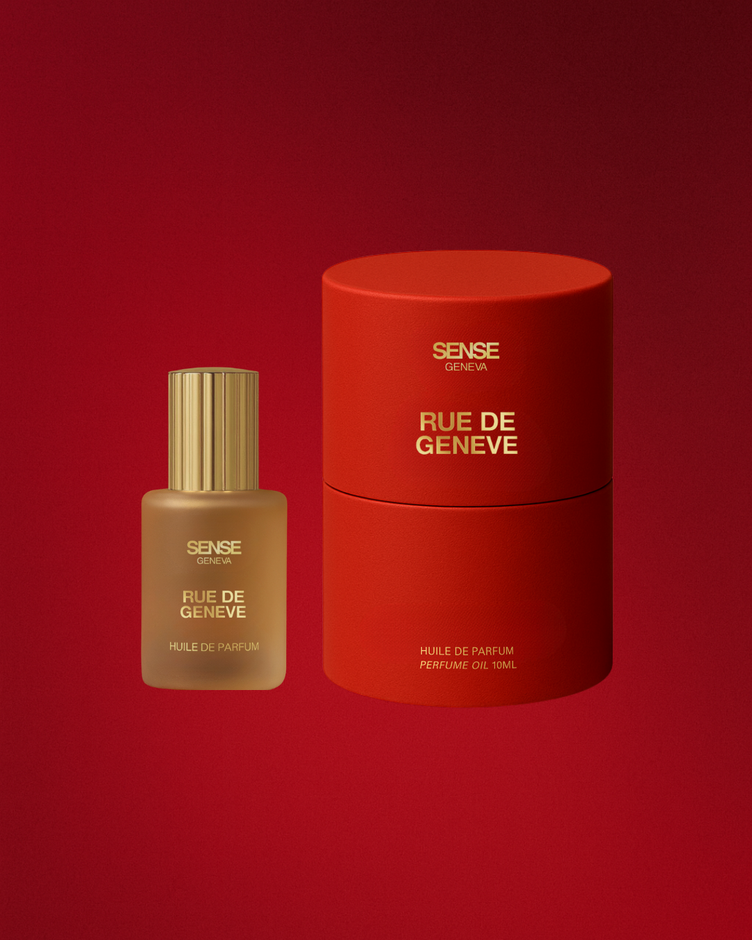 Flacon d’huile de parfum Rue de Genève et son étui cylindrique rouge, posés sur un fond rouge profond.